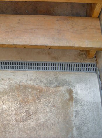 grated basement drain system for the end of staircases that leak